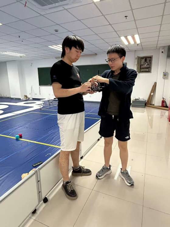 田力(左)、曾少通(右)在实验室进行智能车调试。