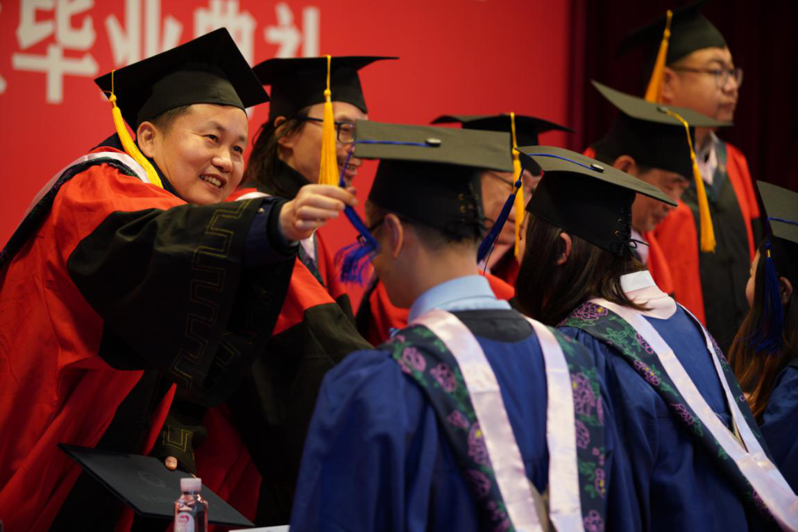 图片说明:导师们为毕业生拨穗正冠